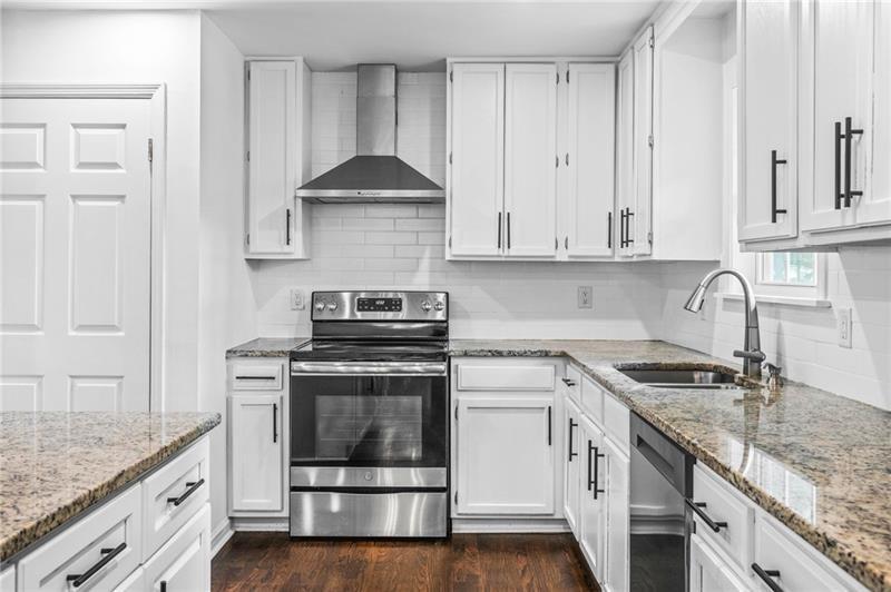 3089 Del Monico Drive Decatur, GA 30032 - Photo 13 of 47 a kitchen with granite countertop a sink a stove and cabinets
