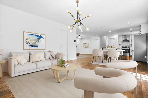 a living room with furniture kitchen and a chandelier
