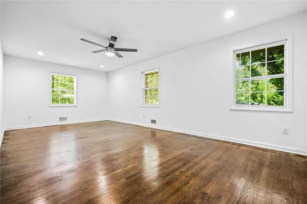 an empty room with a window and a ceiling fan