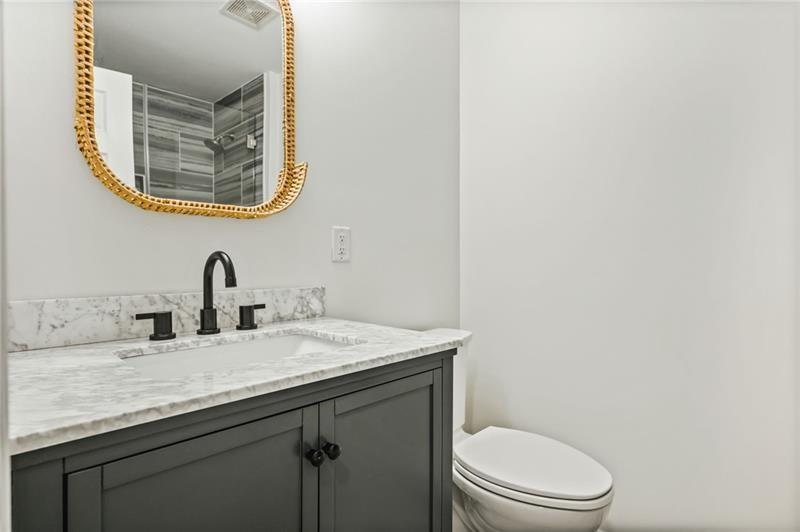 3089 Del Monico Drive Decatur, GA 30032 - Photo 32 of 47 a bathroom with a granite countertop toilet a sink and a mirror