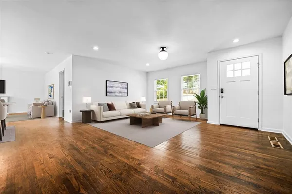 a living room with furniture and a wooden floor
