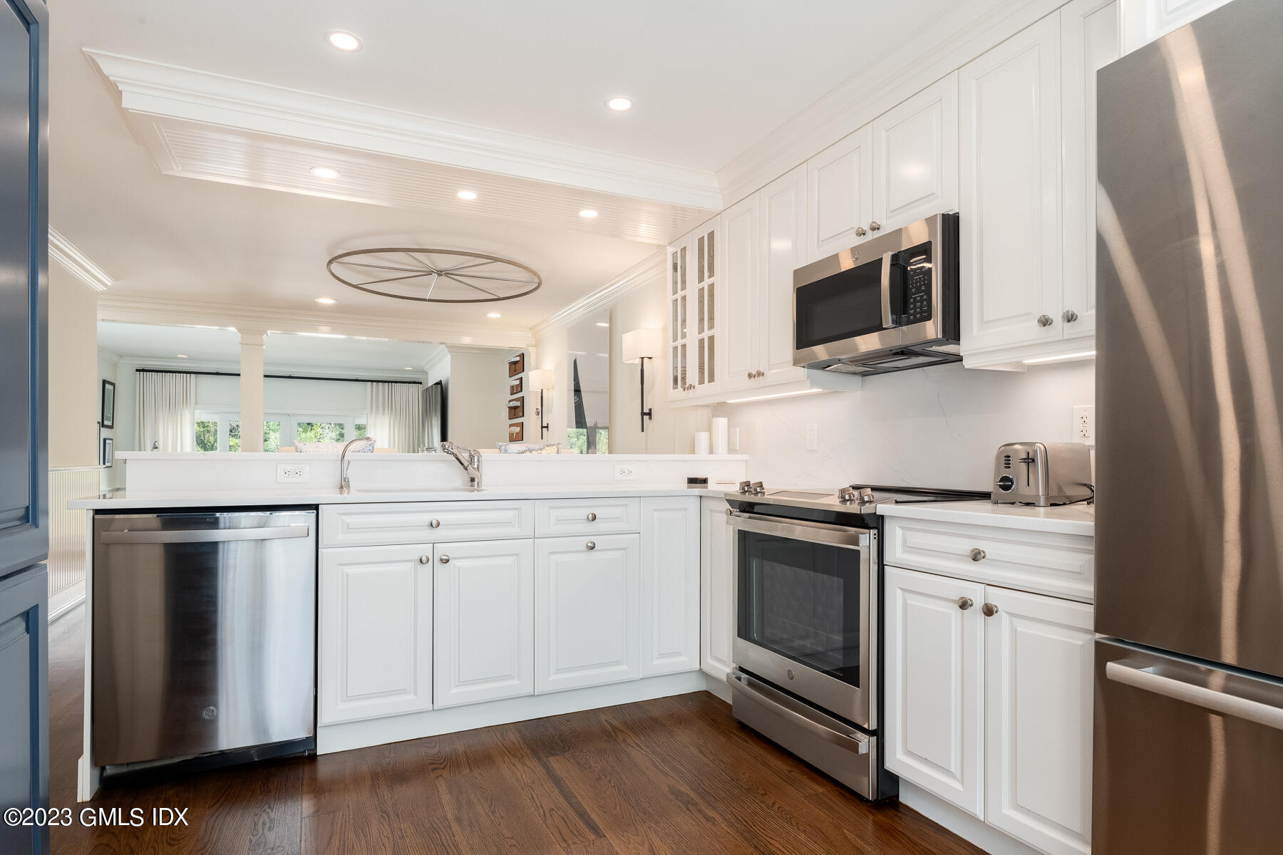 115 River Road, Unit 12 Cos Cob, CT 06807 - Photo 16 of 27 a kitchen with white cabinets stainless steel appliances and wooden floor
