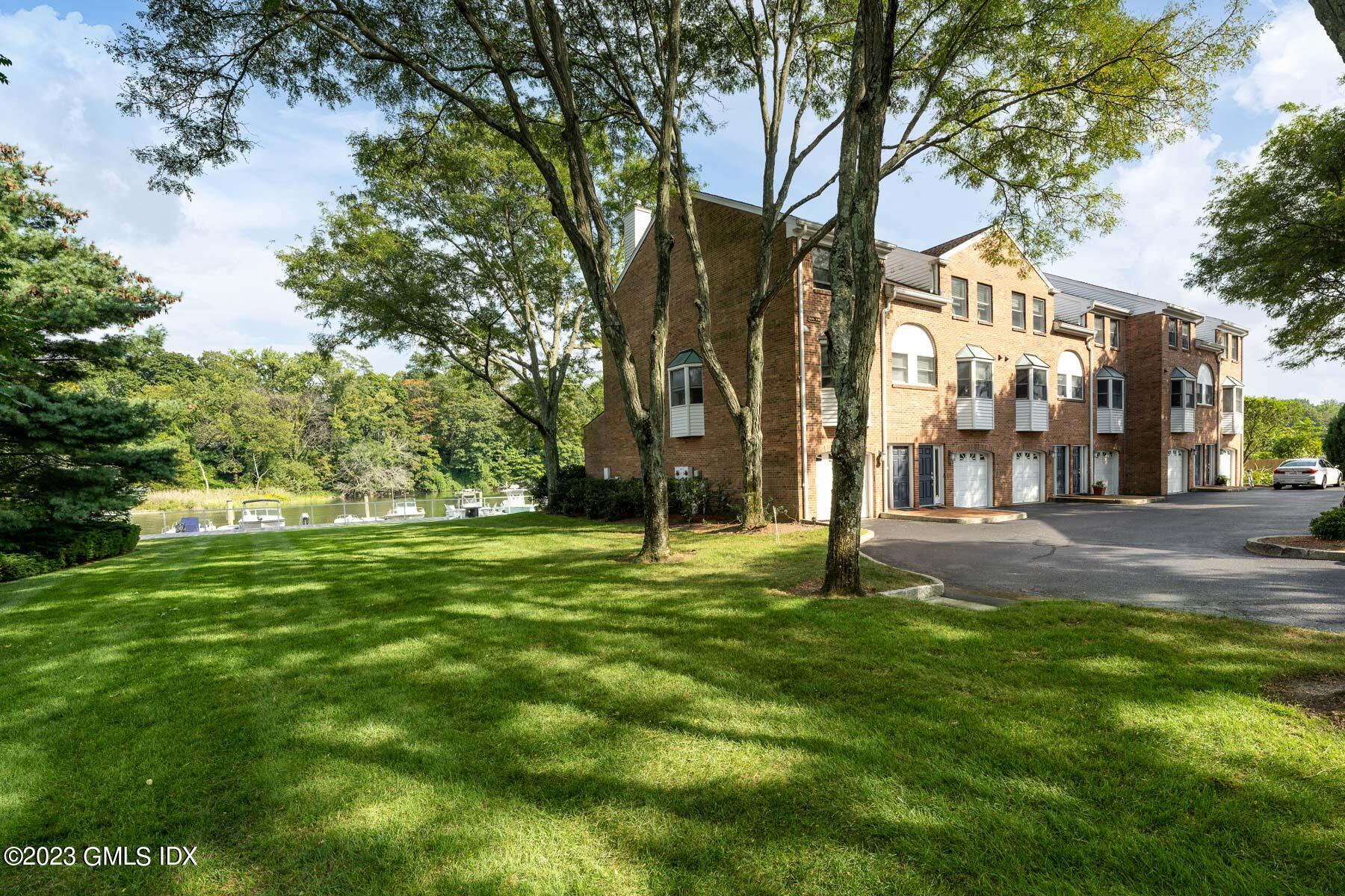 115 River Road, Unit 12 Cos Cob, CT 06807 - Photo 9 of 27 a big yard with lots of green space and trees