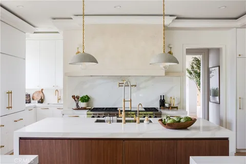 a kitchen with a sink a counter and chairs
