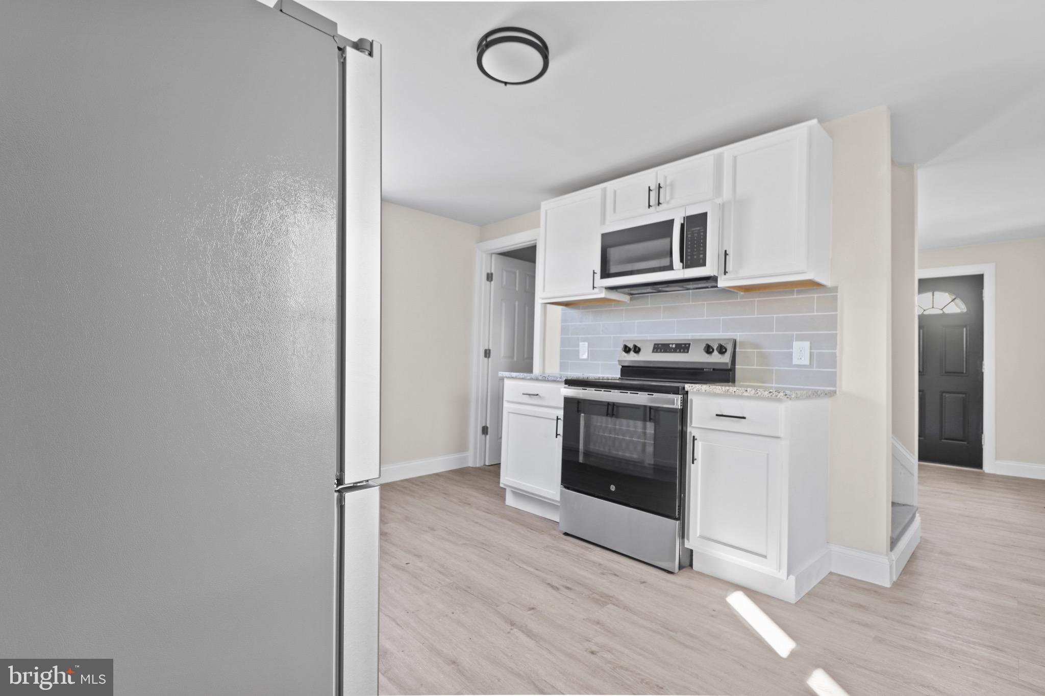 a kitchen with stainless steel appliances granite countertop a stove a microwave and a refrigerator