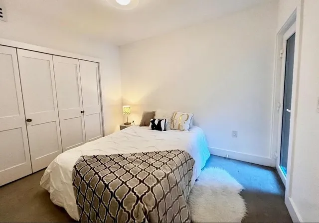 a bed sitting in a bedroom next to a window