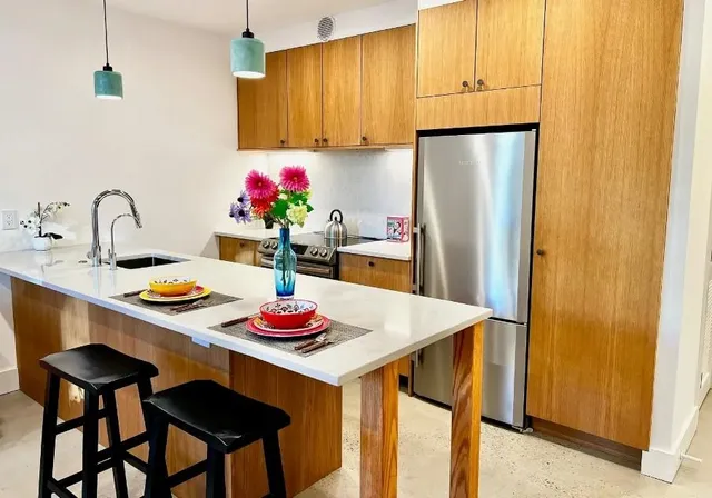 a kitchen with stainless steel appliances granite countertop a dining table and chairs