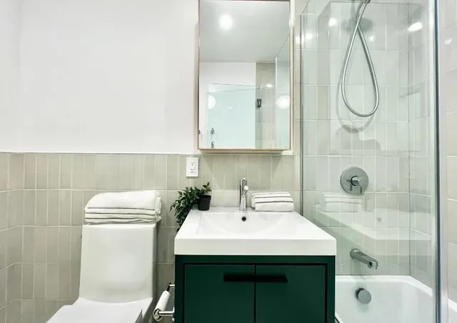 a bathroom with a sink a toilet and shower