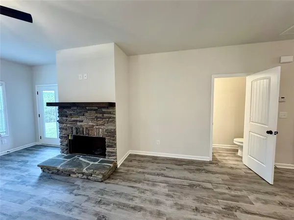 a view of empty room with wooden floor and fireplace
