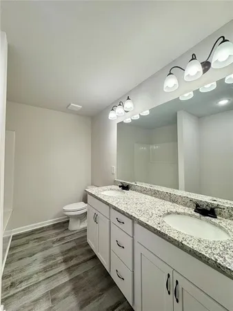 a bathroom with a granite countertop double vanity sink and a mirror