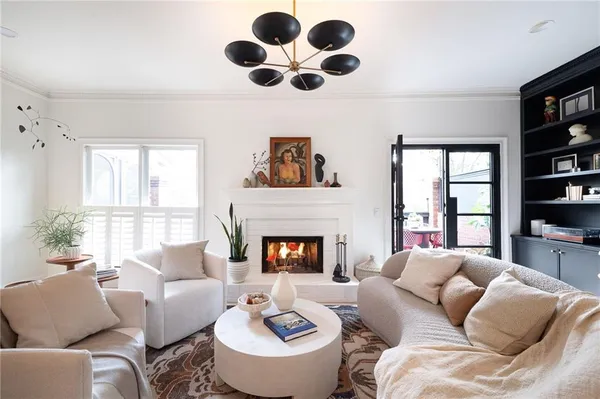 a living room with furniture a fireplace and a large window