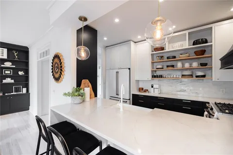 a kitchen with stainless steel appliances a dining table chairs and stove