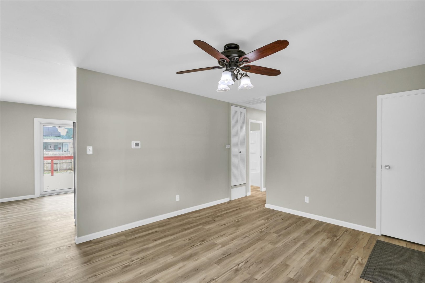 2808 Carrelton Drive Champaign, IL 61821 - Photo 7 of 24 a view of an empty room with wooden floor and a ceiling fan