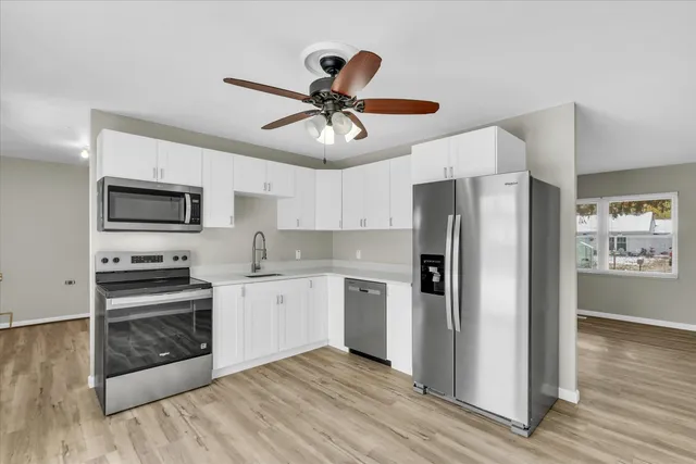a kitchen with stainless steel appliances granite countertop a refrigerator and a stove top oven