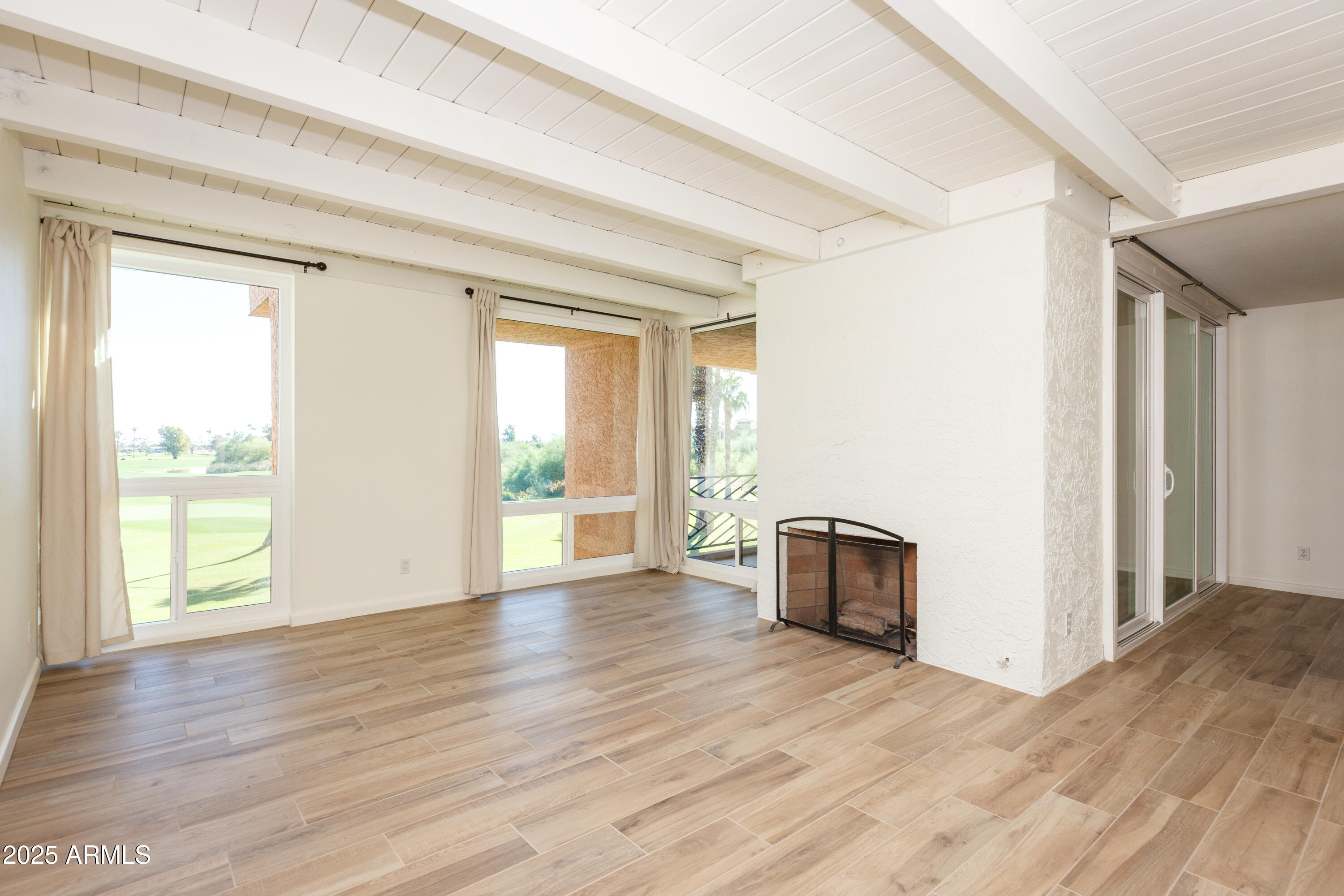 7401 North Scottsdale Road, Unit 51 Paradise Valley, AZ 85253 - Photo 2 of 12 an empty room with wooden floor and windows