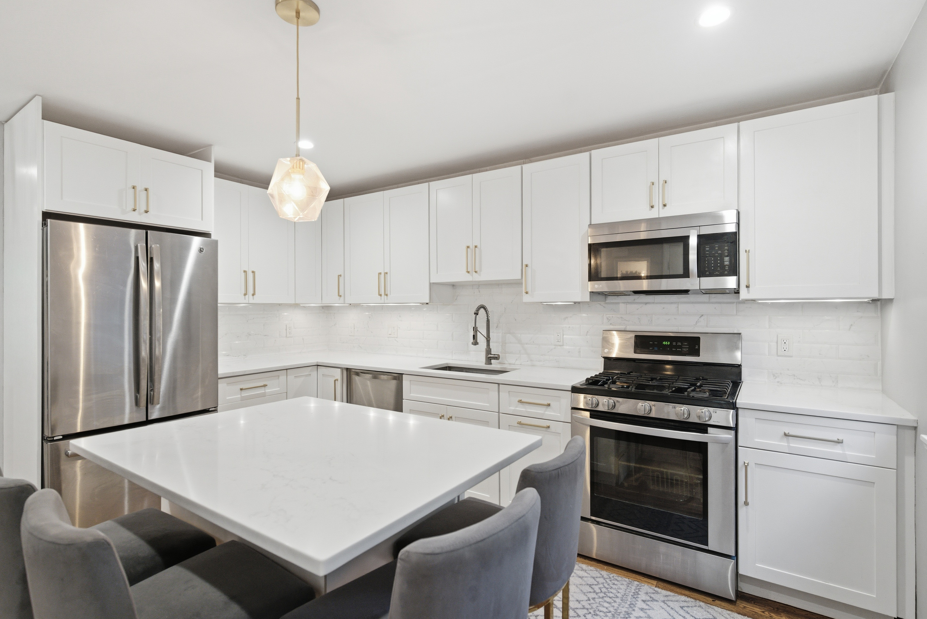 382 Knapps Highway, Unit 382 Fairfield, CT 06825 - Photo 6 of 22 a kitchen with stainless steel appliances a stove a sink a microwave a refrigerator a stove a white table and chairs