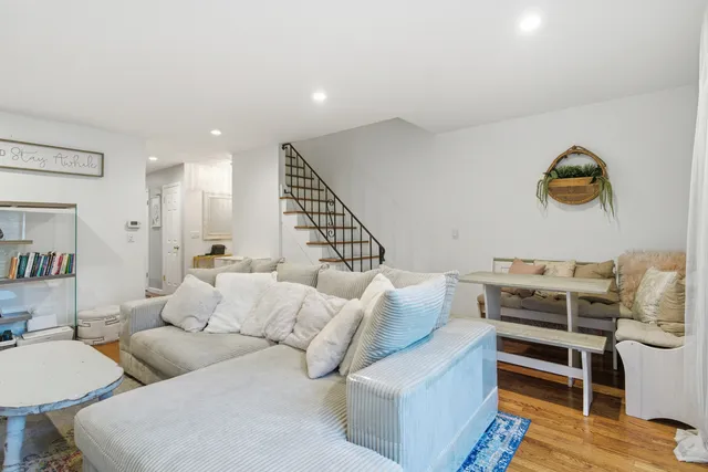 a living room with furniture and a wooden floor
