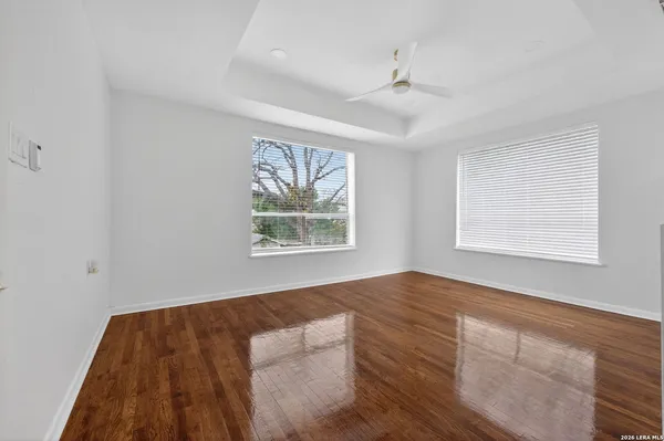a view of an empty room with window and wooden floor