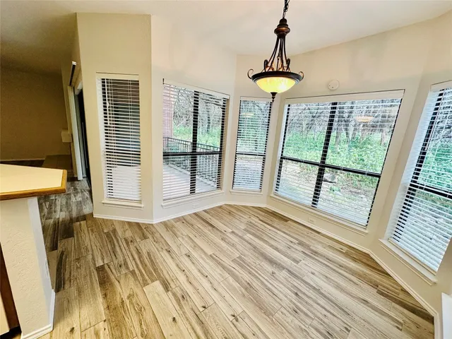 a view of a room with wooden floor and windows
