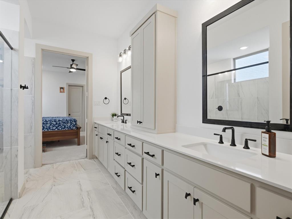 9533 Keep Street Frisco, TX 75035 - Photo 20 of 40 White bathroom cabinetry with matte black hardware and a built-in vertical storage cabinet