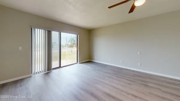 a view of a hallway with wooden floor and a bathroom