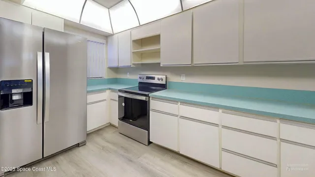 a kitchen with stainless steel appliances white cabinets and a sink