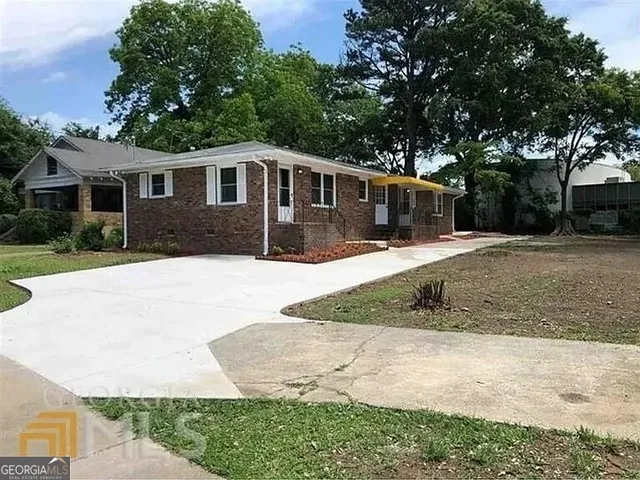 a front view of a house with a yard and trees