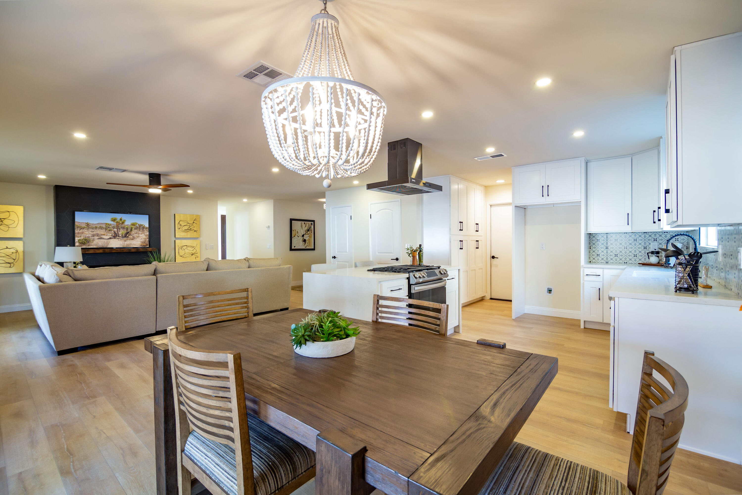 67420 Rango Road Cathedral City, CA 92234 - Photo 17 of 36 a view of a dining room and livingroom with furniture wooden floor a chandelier