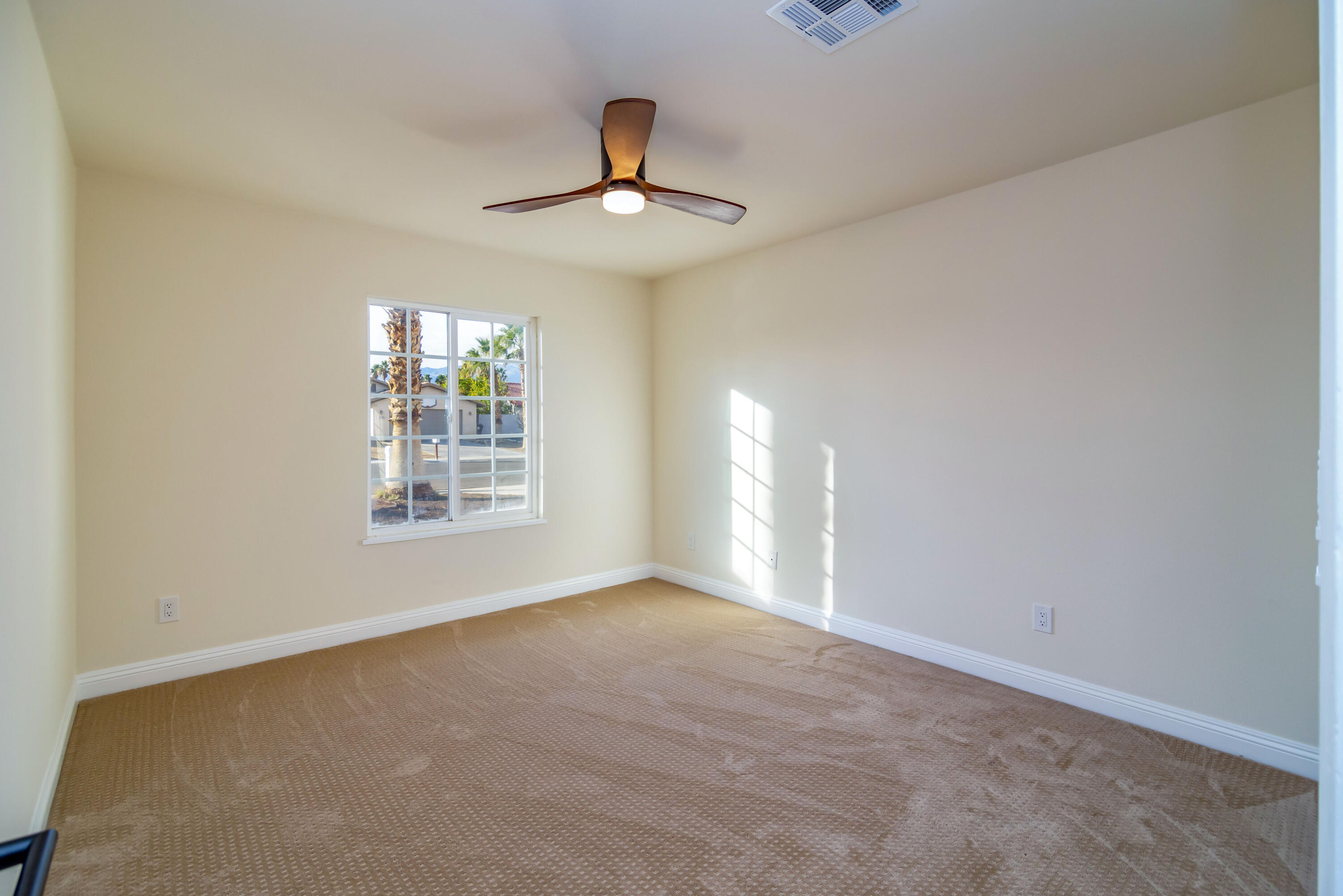 67420 Rango Road Cathedral City, CA 92234 - Photo 19 of 36 an empty room with chandelier fan and windows