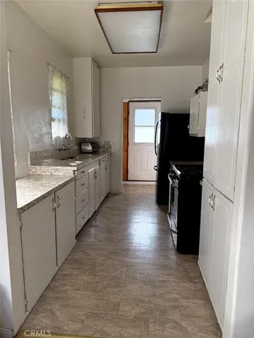 a large kitchen with a refrigerator and a sink