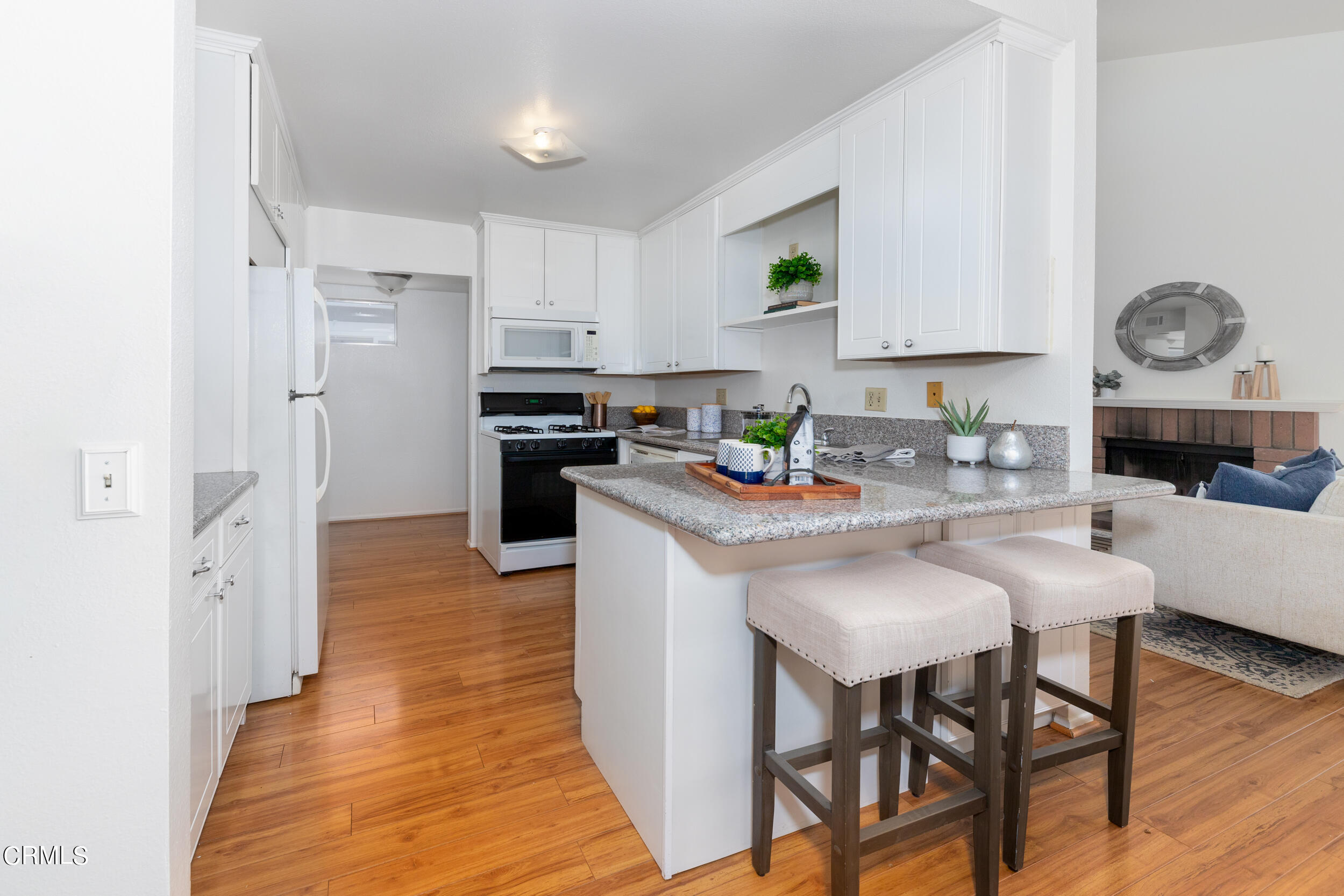 24100 Ave Rancheros, Unit G Diamond Bar, CA 91765 - Photo 8 of 20 a kitchen with stainless steel appliances granite countertop a stove a sink dishwasher a refrigerator a microwave oven with cabinets and wooden floor