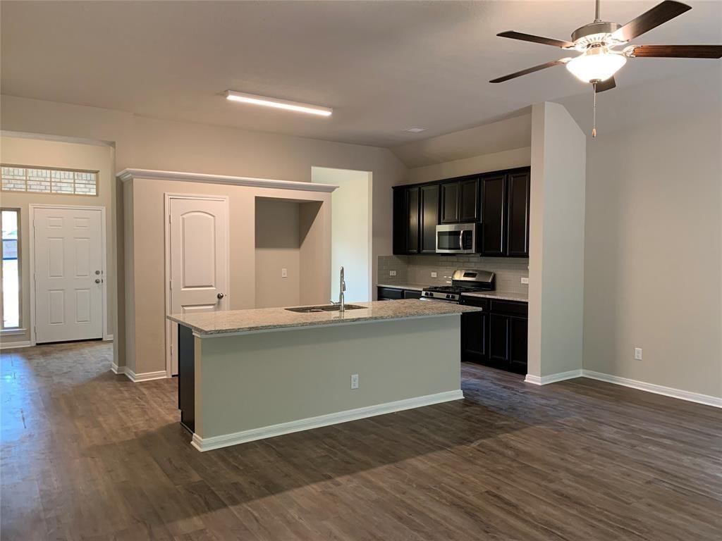 994 Arbor Crossing Conroe, TX 77303 - Photo 2 of 9 a kitchen with granite countertop a stove top oven and cabinets