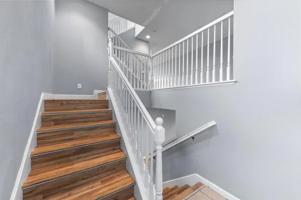 a view of a hallway with wooden floor and staircase