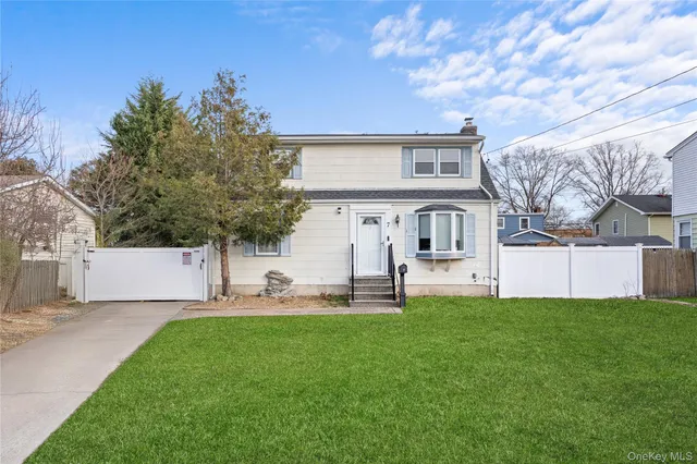 a front view of a house with a yard and a tree