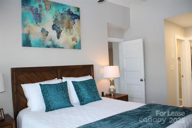 a bedroom with a bed and a painting on the wall