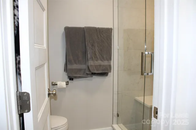 a bathroom with a toilet and a shower