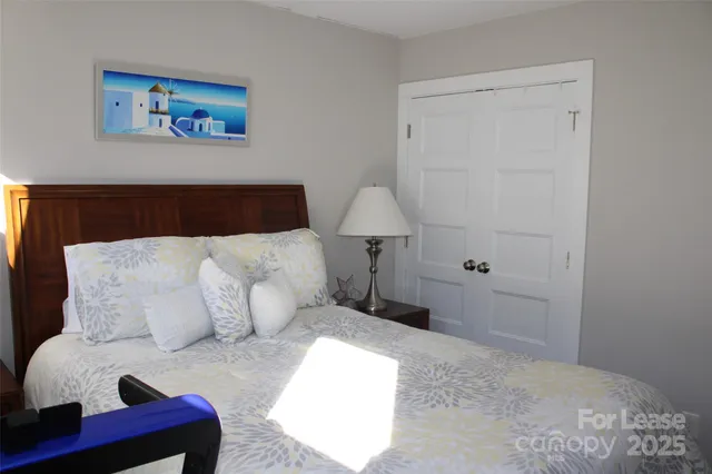 a bedroom with a bed and a lamp on dresser