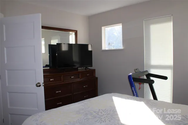 a bedroom with a bed and flat screen tv