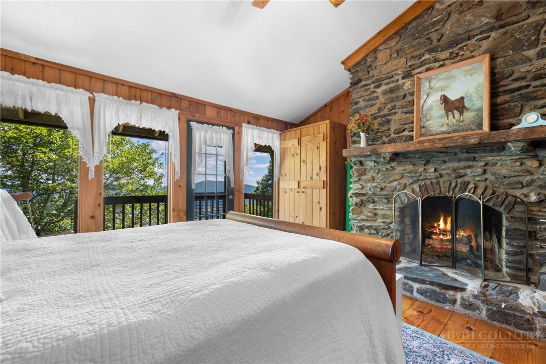 2177 Homestead Road Todd, NC 28684 - Photo 18 of 49 a large bedroom with a bed and a fireplace