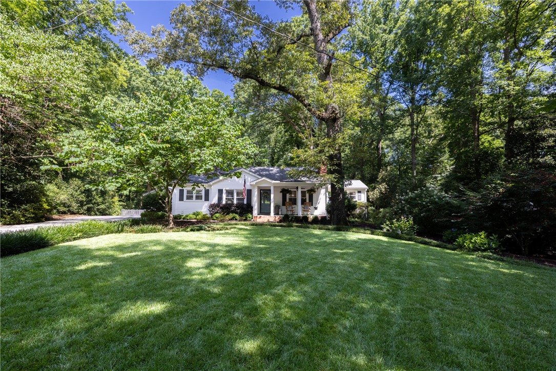 203 Augusta Road Clemson, SC 29631 - Photo 3 of 31 A classic bungalow home is nestled amongst verdant landscaping, offering a private, peaceful retreat.