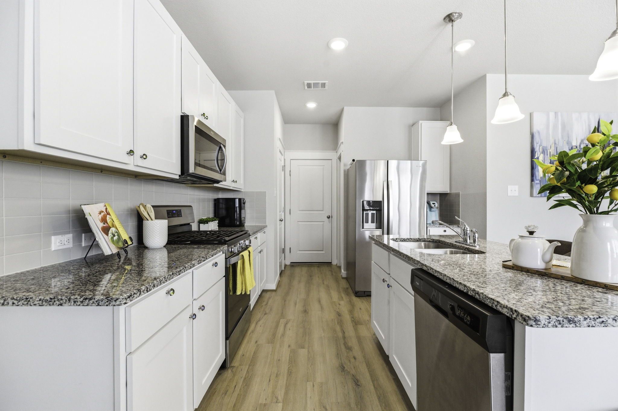 a kitchen with kitchen island granite countertop a sink a counter space appliances and cabinets