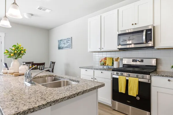a kitchen with stainless steel appliances granite countertop a sink stove and microwave