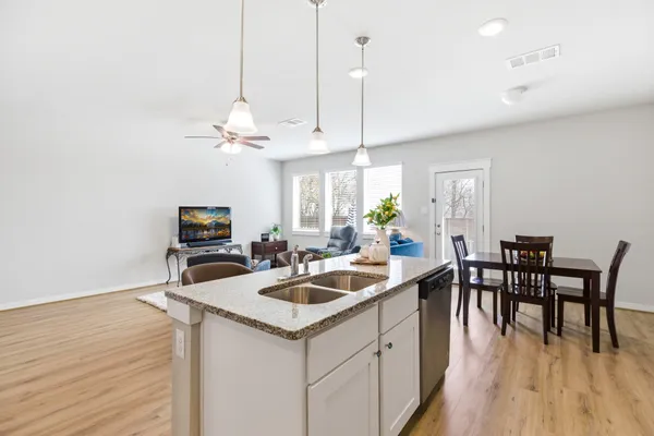 a kitchen with a table chairs and wooden floor