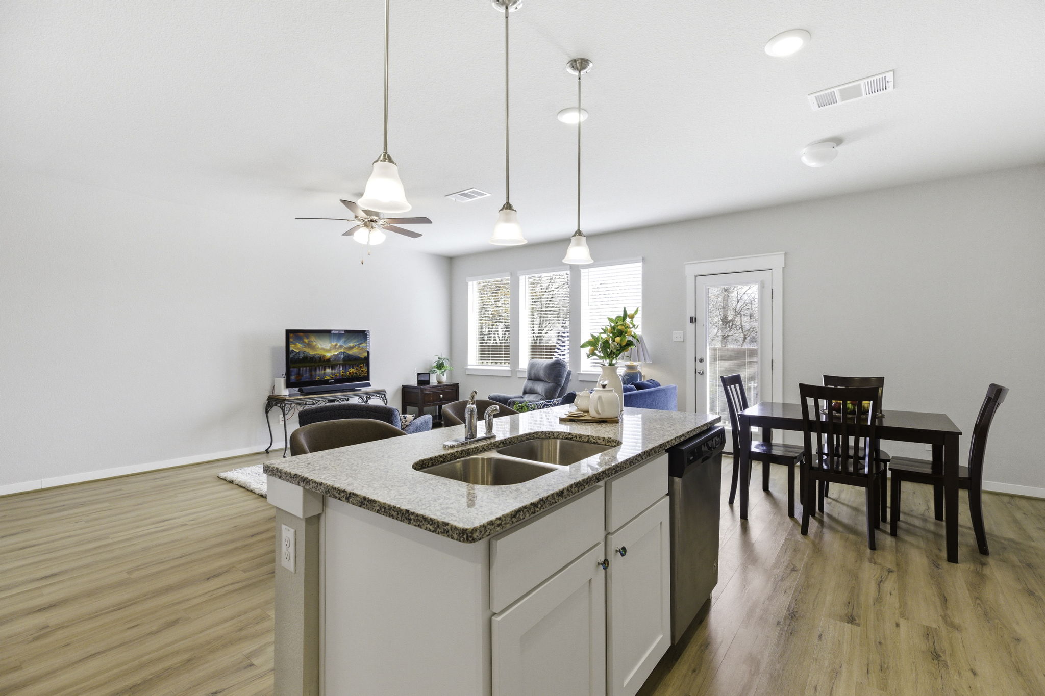17205 Leafroller Drive, Unit B Pflugerville, TX 78660 - Photo 12 of 32 a kitchen with a table chairs and wooden floor