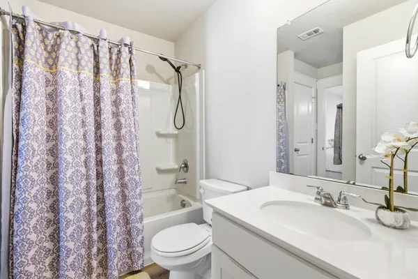 a bathroom with a granite countertop sink toilet and shower