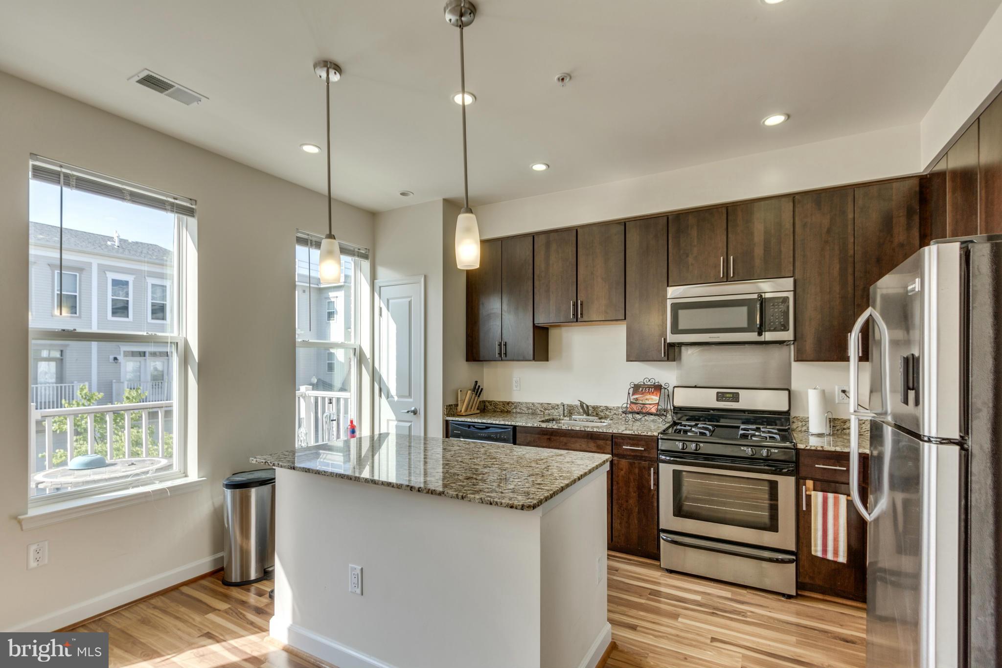 2524 Sheridan Road Southeast Washington, DC 20020 - Photo 9 of 20 a kitchen with stainless steel appliances granite countertop a stove refrigerator and microwave