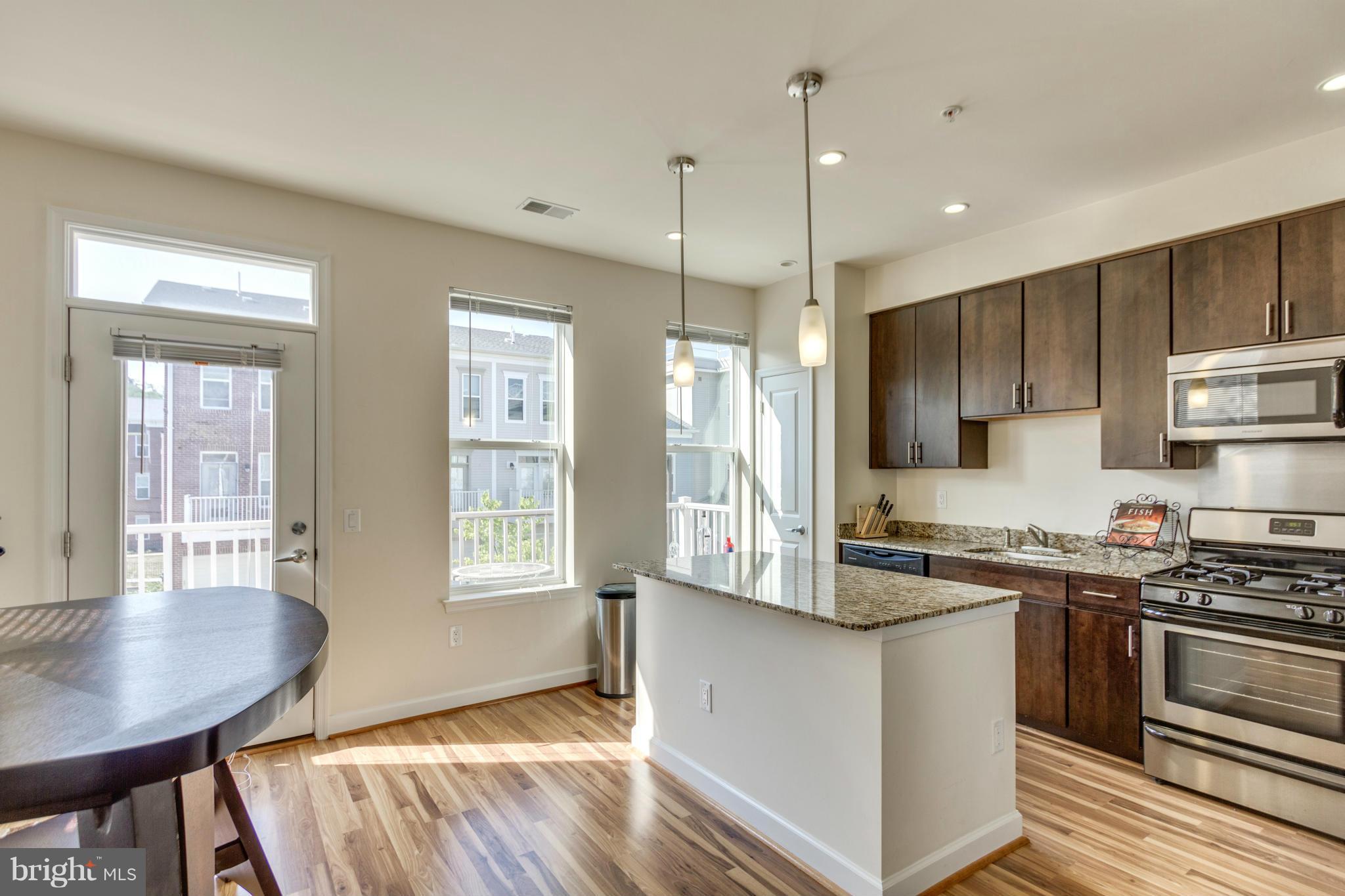 2524 Sheridan Road Southeast Washington, DC 20020 - Photo 10 of 20 a kitchen with stainless steel appliances granite countertop a stove a sink dishwasher a refrigerator white cabinets and wooden floor