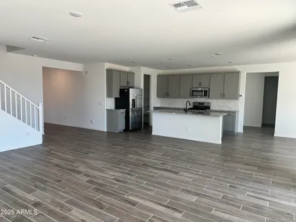 a view of a kitchen with a sink a refrigerator and cabinets