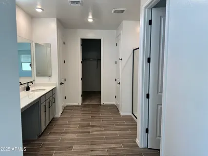 a large kitchen with a sink and a wooden floor