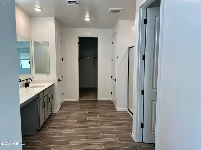 a large kitchen with a sink and a wooden floor